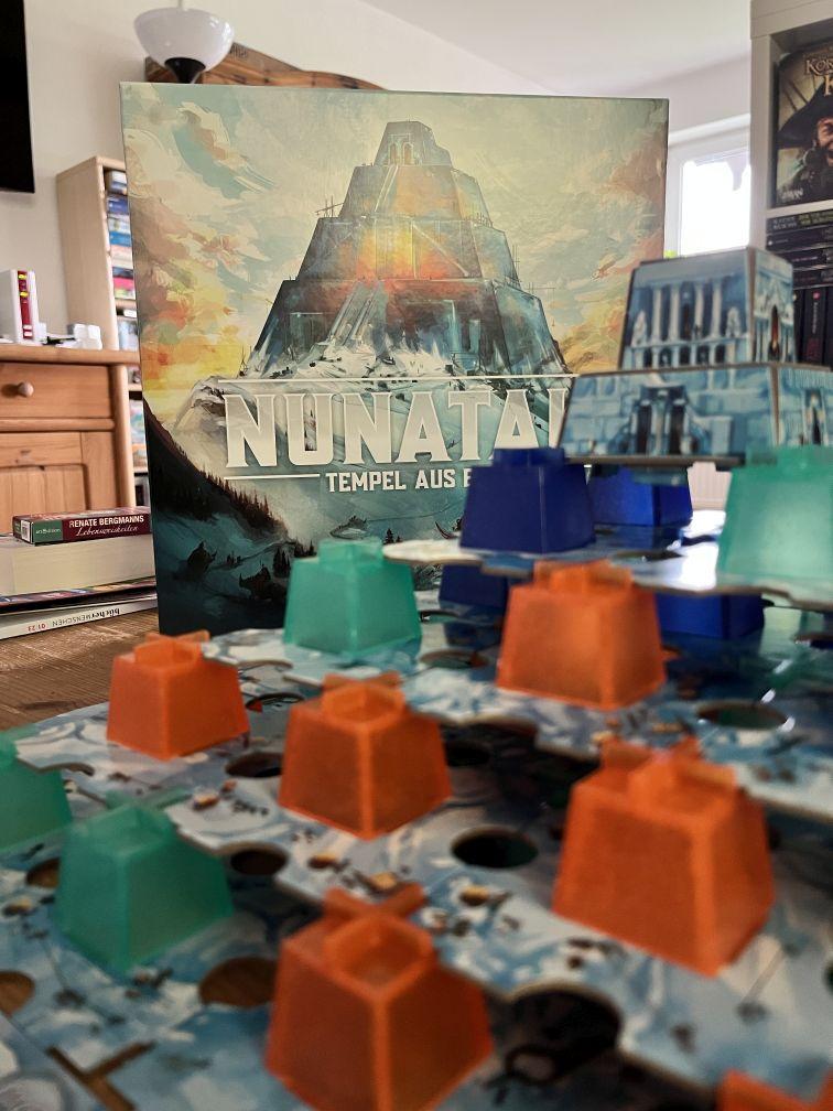 Eine Aufnahme einer abgeschlossenen Partie von Nunatak. Im Vordergrund befindet sich der im Spiel gebaute Turm aus Eis, während im Hintergrund die Schachtel sichtbar ist.